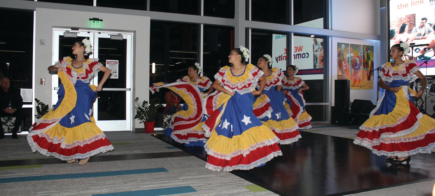 A group of dancers in colorful costumes demonstrates a traditional dance at the Hispanic Festival.